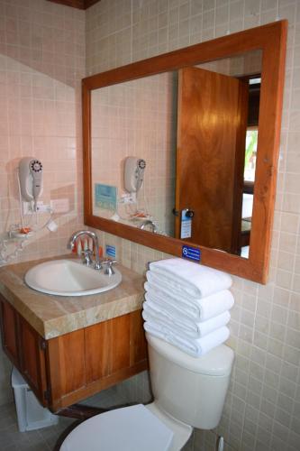 a bathroom with a sink and a toilet and a mirror at Decameron Marazul - All Inclusive in San Andrés