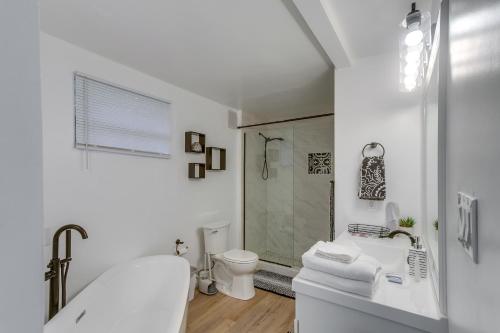 uma casa de banho branca com uma banheira e um WC em Charming Valdosta Home with Deck and Outdoor Dining! em Valdosta