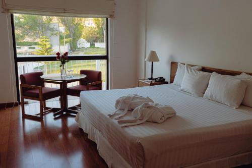 a hotel room with a bed with a robe on it at BTH Hotel Arequipa Lake in Arequipa