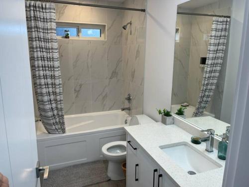 ein Badezimmer mit einer Badewanne, einem WC und einem Waschbecken in der Unterkunft Stunning 5-bed Retreat in Sunshine Valley in Sunshine Valley