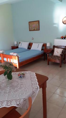 a bedroom with a bed and a table and chairs at Lampros apartments in Loutra Edipsou