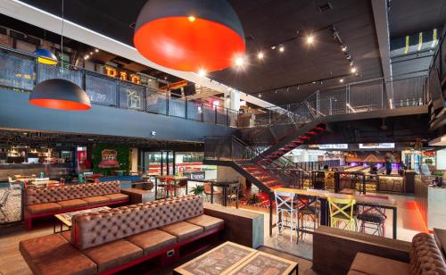 a restaurant with couches and tables and a staircase at Apartamento con piscina, frente a CC Mayorca in Sabaneta