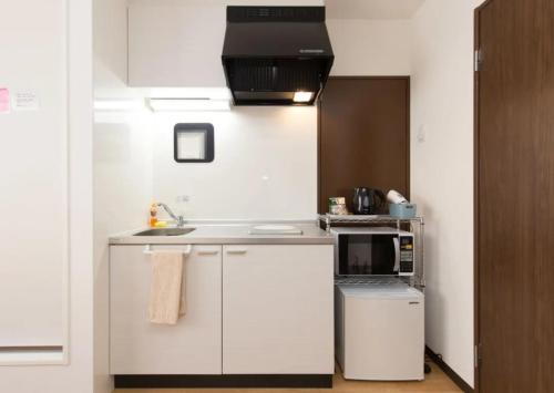 uma cozinha branca com um lavatório e um micro-ondas em HOTEL LUCKY - Vacation STAY 49954v em Osaka