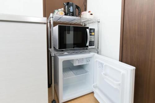 um micro-ondas sentado dentro de um frigorífico em HOTEL LUCKY - Vacation STAY 49954v em Osaka