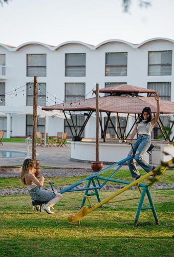two girls playing on a playground in a park at BTH Hotel Arequipa Lake in Arequipa