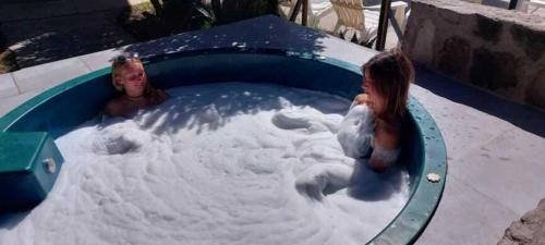 two children are playing in a pool of snow at Tradicion Colca in Yanque