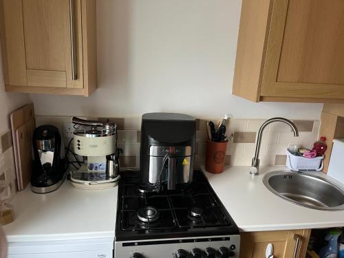 a kitchen counter with a coffee maker on a stove at The Dog House in Birkenhead