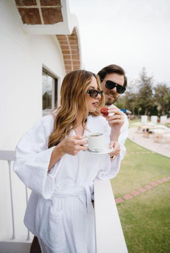 a man and a woman holding a cup of coffee at BTH Hotel Arequipa Lake in Arequipa