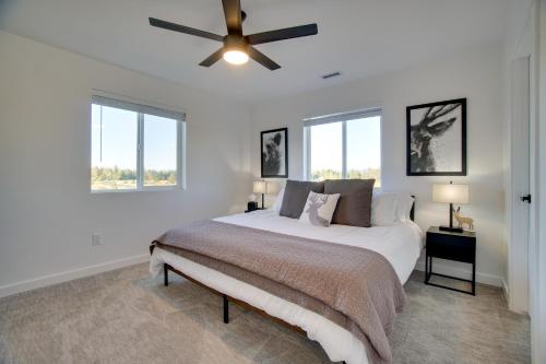 a white bedroom with a bed and a ceiling fan at Modern Donnelly Cabin with Private Hot Tub in Donnelly