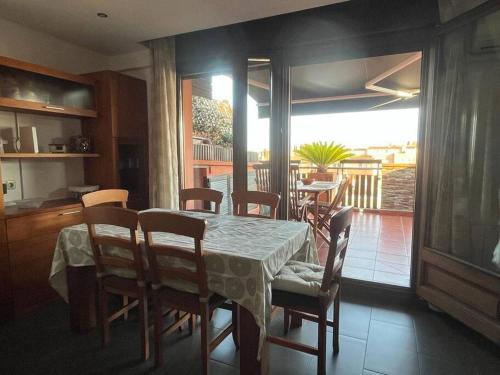 een eetkamer met een tafel en stoelen en een balkon bij Ático luminoso céntrico y cómodo in Figueres