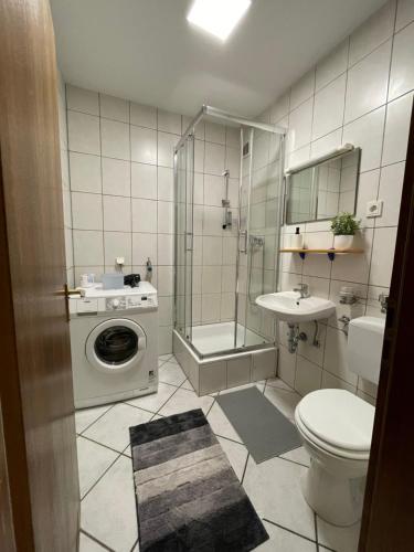 y baño con ducha, aseo y lavadora. en Premium Apartment 2, en Dillingen an der Saar