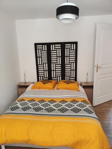 a bedroom with a bed with orange pillows on it at Résidence les deux Nestes in Arreau