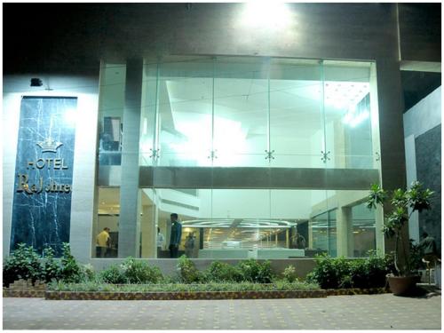 a large glass building with people in it at night at Hotel Rajshree & Spa in Chandīgarh