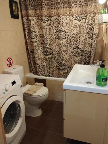 a bathroom with a toilet sink and a shower curtain at Margeo house in Perdika