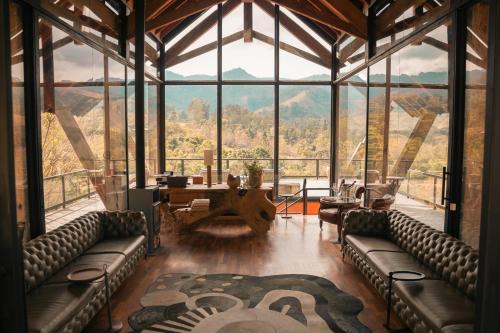 a large room with couches and a table with a view at Botanique Hotel Experience - Campos do Jordão in Campos do Jordão
