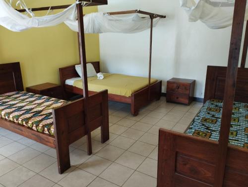 a room with two beds and a canopy bed at Cefa Hostel in Dar es Salaam