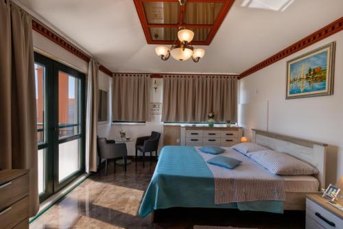 a bedroom with a bed and a kitchen with a table at Vila Bonita in Klek