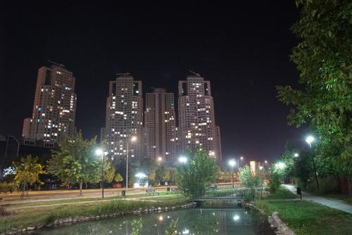 a city skyline at night with a pond in a park at Skopje Sky Apartments & Floor 33th 28th & 25th & 19th & 13th 12th With Pool & Spa & Fitness & Parking Included in Price in Skopje