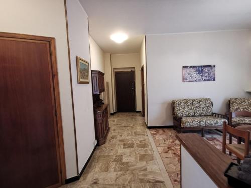 een hal met een woonkamer met een bank en stoelen bij CasaUmberto in Nizza Monferrato