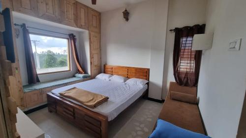 a small bedroom with a bed and a window at Sandiago Villa 2 Bhk House - Only Bachelors Adults in Ooty