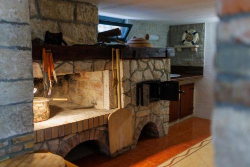 a stone fireplace in a living room with a counter at Vila Bonita in Klek