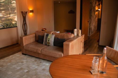 a living room with a couch and a table at Botanique Hotel Experience - Campos do Jordão in Campos do Jordão