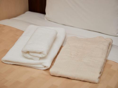 那霸的住宿－Grand Cabin Hotel Naha Oroku - Vacation STAY 46864v，两条毛巾位于木地板上