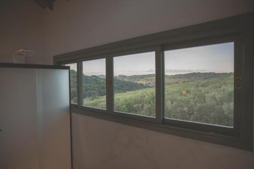 a window in a room with a view of a mountain at Pousada Calza - Vale dos Vinhedos - Bento Gonçalves in Bento Gonçalves