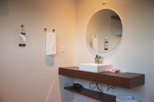 a bathroom with a sink and a mirror at Pousada Calza - Vale dos Vinhedos - Bento Gonçalves in Bento Gonçalves