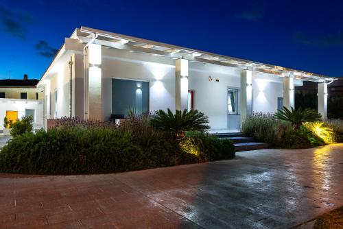 a white house with a pathway in front of it at B & b Venere in Paestum