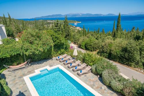 an outdoor swimming pool with lounge chairs and a view of the water at Garden House, up to 8px 1km from Fiskardo in Tselendáta