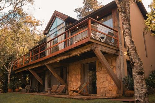a house with a balcony on the side of it at Botanique Hotel Experience - Campos do Jordão in Campos do Jordão