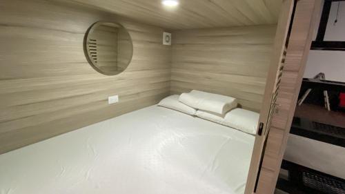 安地瓜的住宿－Capsulas La Sin Ventura，一张小床,位于一个小房间里,配有镜子