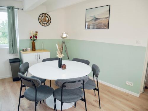une salle à manger avec une table et des chaises blanches dans l'établissement Le coup de coeur d'Honfleur, à Équemauville