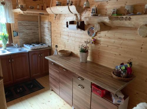una cucina con pareti in legno e piano di lavoro in legno di Całoroczny Domek Oliwia DELUX na wyłączność a Lubiatowo