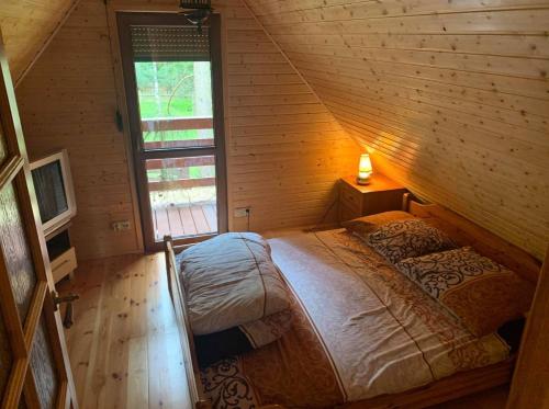 a bedroom with a bed in a wooden cabin at Całoroczny Domek Oliwia DELUX na wyłączność in Lubiatowo