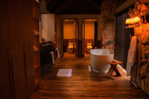 a bathroom with a tub on a wooden floor at Botanique Hotel Experience - Campos do Jordão in Campos do Jordão