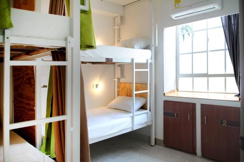 a dorm room with bunk beds and a window at Cacao Hostel Santa Marta in Santa Marta