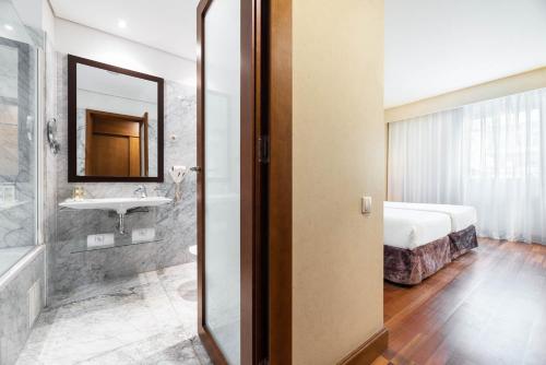 a bathroom with a sink and a mirror at Eurostars das Artes in Porto