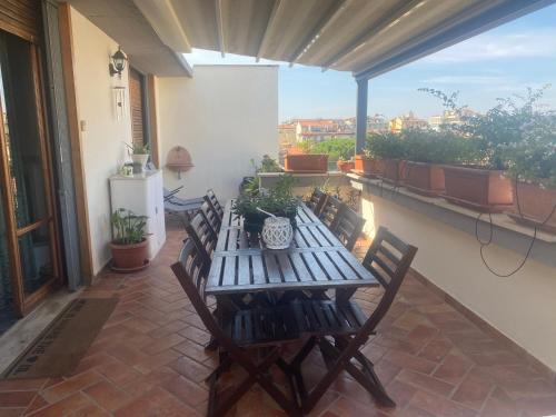 een patio met een houten tafel en stoelen op een balkon bij La casa di Dani in Florence