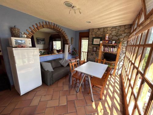 uma cozinha e sala de estar com uma mesa e um frigorífico em Cal Tià em Viliella