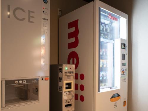 an ice vending machine next to a wall with a sign at REF Kansai Airport by VESSEL HOTELS in Izumi-Sano