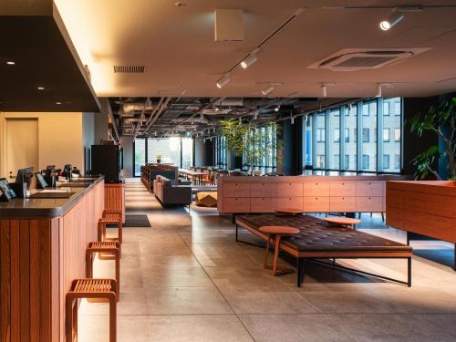a restaurant with a bar and tables and chairs at REF Kansai Airport by VESSEL HOTELS in Izumi-Sano