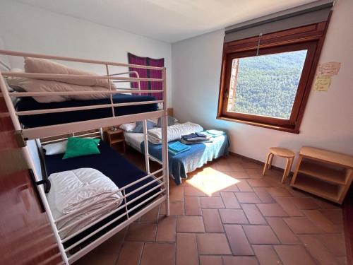 ViliellaにあるCal Tiàの二段ベッド2台と窓が備わる客室です。