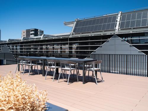 a row of tables and chairs on the roof of a building at REF Kansai Airport by VESSEL HOTELS in Izumi-Sano