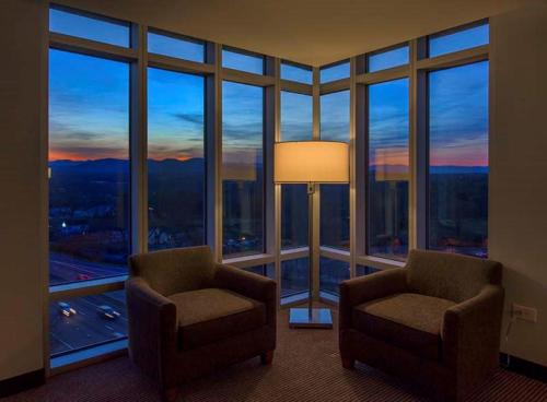 a room with two chairs in front of a large window at DoubleTree by Hilton Asheville Downtown in Asheville