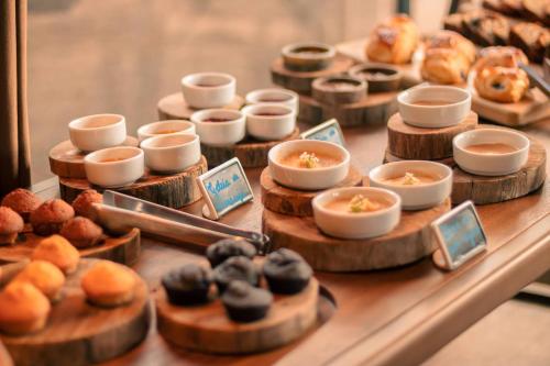 a display of donuts and other pastries on a table at Botanique Hotel Experience - Campos do Jordão in Campos do Jordão