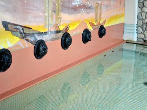 une rangée de quatre boules noires sur un mur dans l'établissement Bokkai Onsen Seaside Villa Bokkai - Vacation STAY 69007v, à Shika