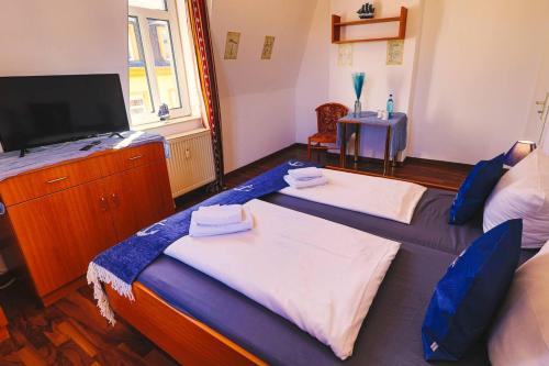 1 dormitorio con 2 camas y un tocador con TV en Ryde & Hyde Budget Hotel en Dresden