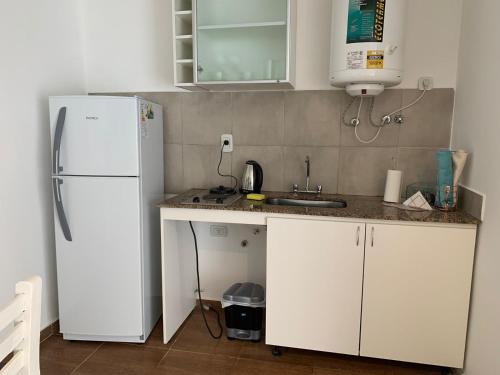 uma cozinha com um frigorífico branco e um lavatório em Edificio Rey Niño em Posadas
